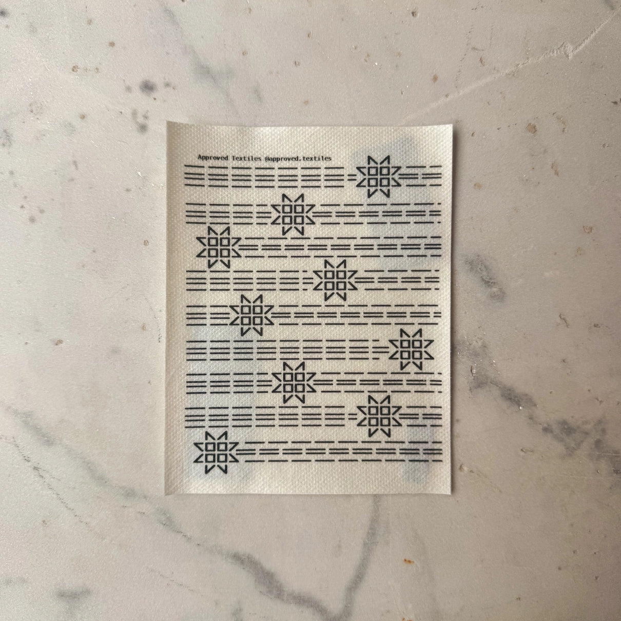 Patterned paper with geometric star designs on a marble surface